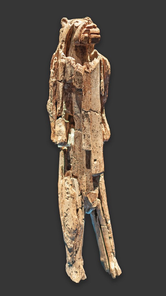 An ivory figurine of an anthropomorphic lion, weathered by time.